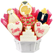Wedding themed cookie bouquet with dress, ring, hearts, bouquet, cake, and tuxedo cookies