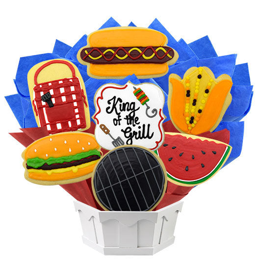 Grill-themed cookie bouquet with hot dog, burger, grill, corn, watermelon, picnic basket and 'King of the Grill' centerpiece.