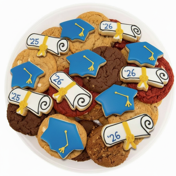 Decorative cookies shaped like graduation caps and scrolls on a white plate.