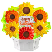 Birthday sunflower cookie bouquet with yellow and orange floral cookies in a white basket.