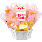 Pink baby girl cookie bouquet with onesie, bottle, carriage, and duck shapes in gift basket