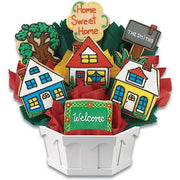 House-shaped decorated cookies arranged in a gift bouquet with welcome signs in a white basket.