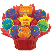 Colorful thank you cookie bouquet with iced messages in multiple languages, arranged in a red basket.